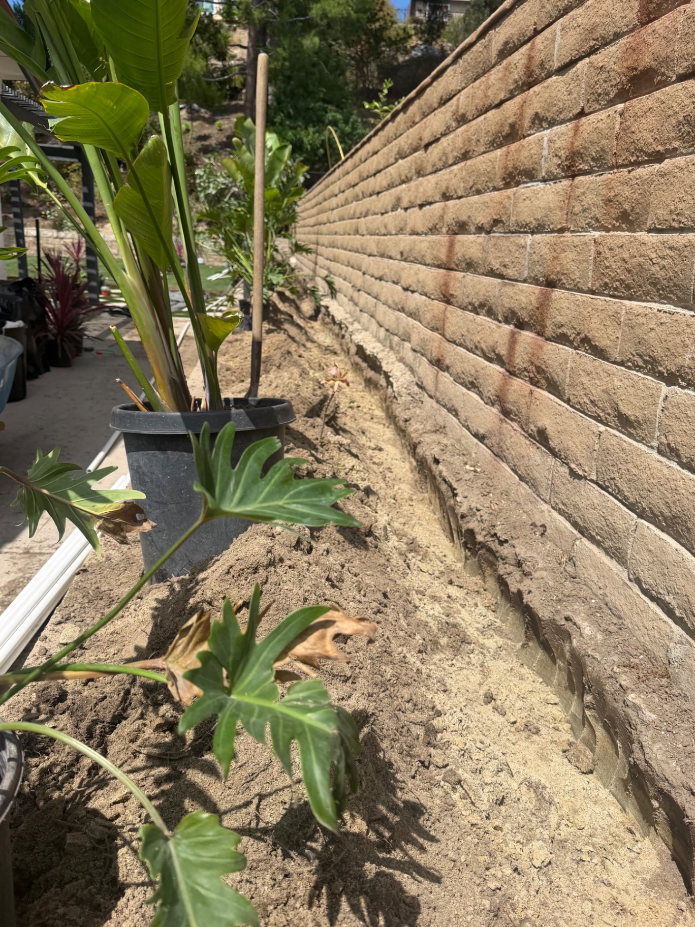 New planting bed prepared along a block retaining wall